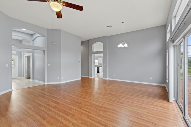 empty room featuring light hardwood / wood-style flooring and ceiling fan with notable chandelier