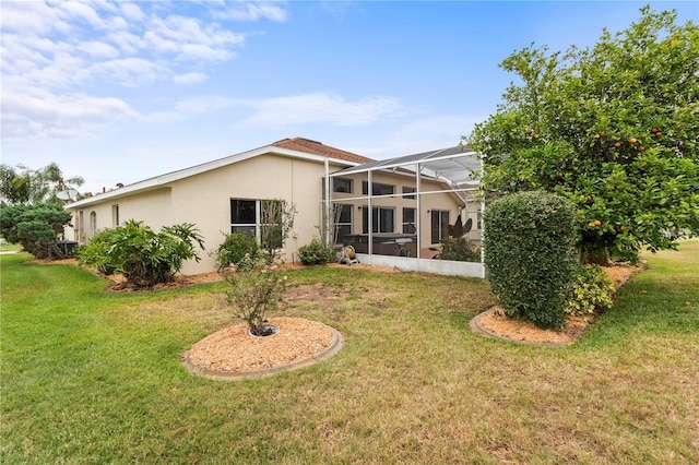 back of property featuring a lanai and a yard