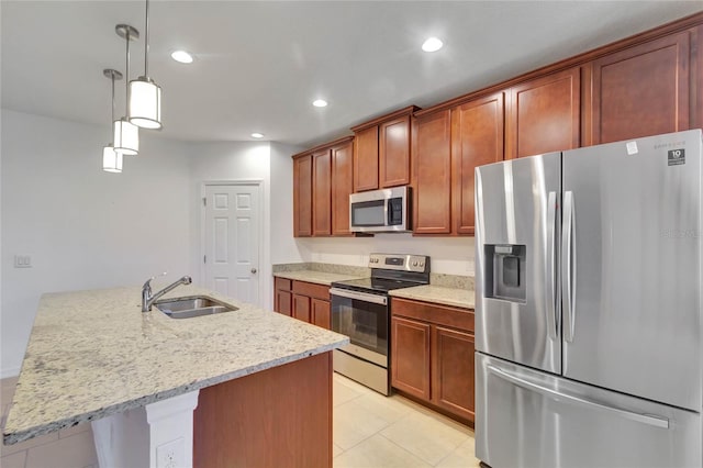 kitchen featuring pendant lighting, a center island with sink, sink, appliances with stainless steel finishes, and light tile patterned flooring