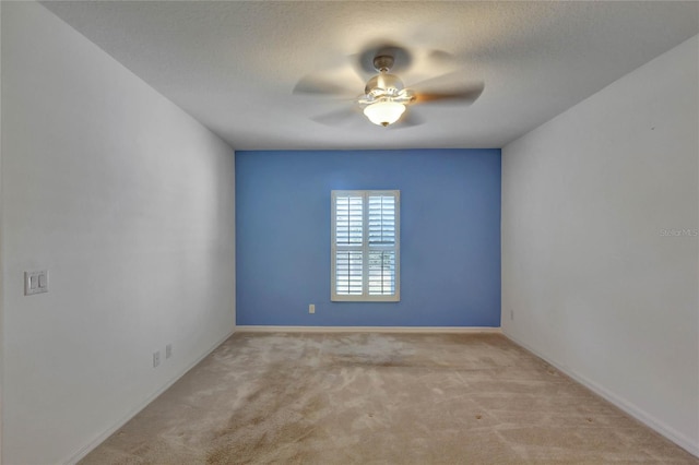 carpeted spare room featuring ceiling fan and a textured ceiling