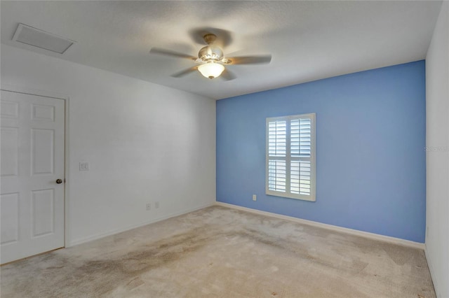 carpeted spare room featuring ceiling fan