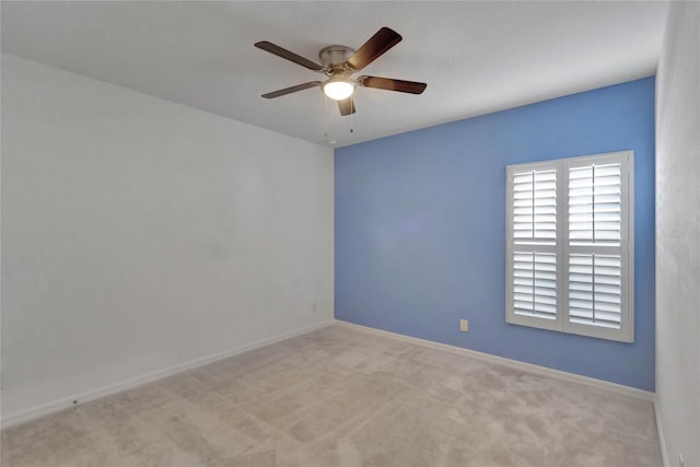 spare room with light colored carpet and ceiling fan