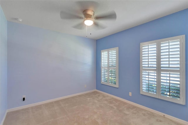 spare room featuring ceiling fan and light carpet