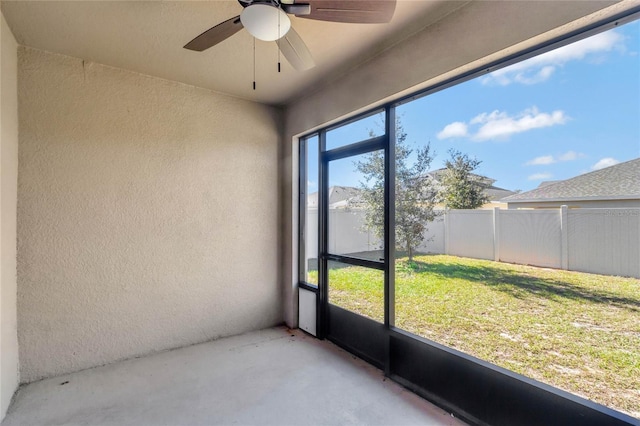 unfurnished sunroom with ceiling fan