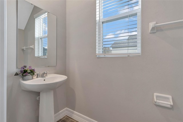 bathroom featuring tile patterned flooring, lofted ceiling, and sink