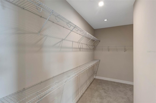 walk in closet featuring light carpet