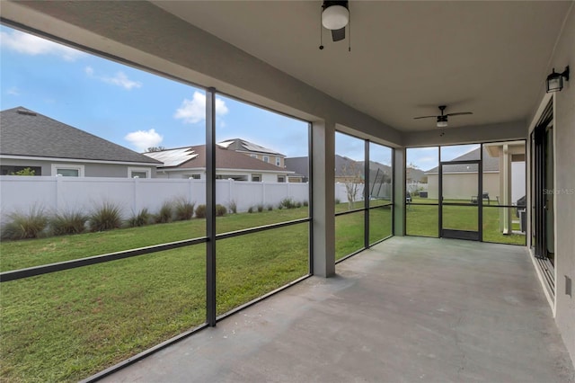 unfurnished sunroom with ceiling fan