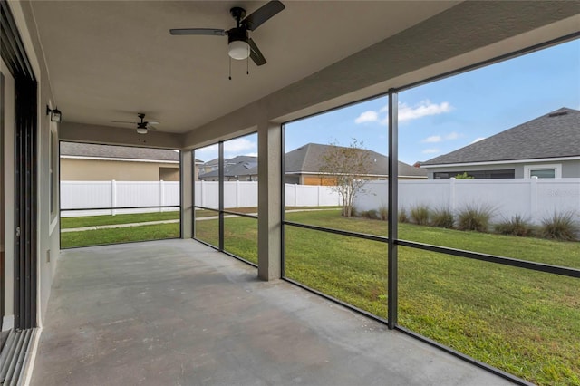 unfurnished sunroom with ceiling fan