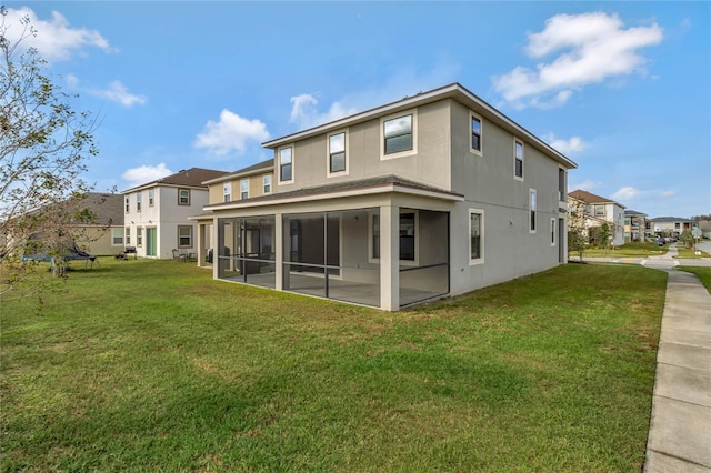 back of property featuring a sunroom and a lawn