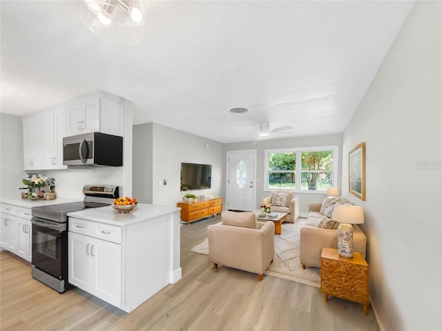 kitchen featuring appliances with stainless steel finishes, light hardwood / wood-style flooring, white cabinetry, and ceiling fan