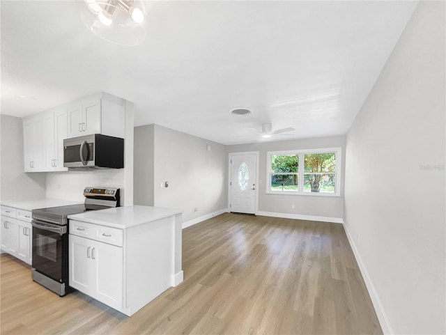 kitchen featuring backsplash, white cabinets, ceiling fan, light hardwood / wood-style floors, and stainless steel appliances