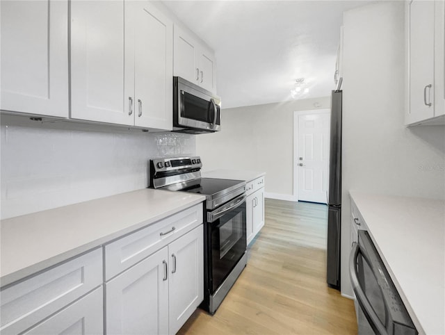 kitchen featuring white cabinets, tasteful backsplash, stainless steel appliances, and light hardwood / wood-style flooring