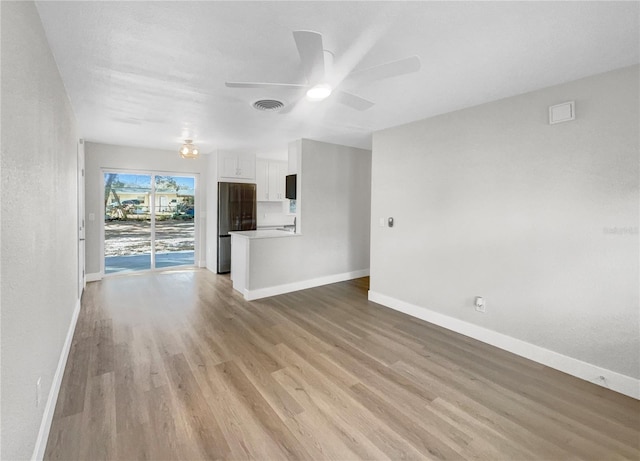 unfurnished living room with ceiling fan and light hardwood / wood-style floors