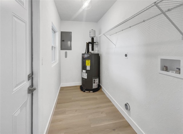 utility room with electric panel and water heater