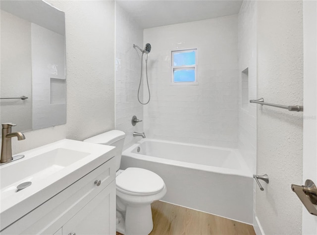 full bathroom featuring hardwood / wood-style floors, vanity, toilet, and tiled shower / bath