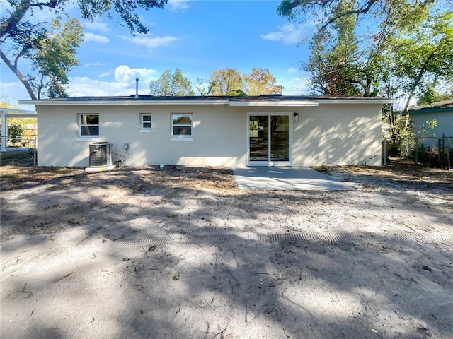 rear view of house with central AC unit and a patio area