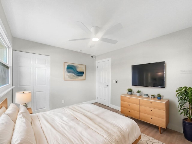 bedroom featuring light wood-type flooring, a closet, and ceiling fan