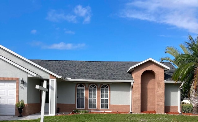 doorway to property with a garage and a yard