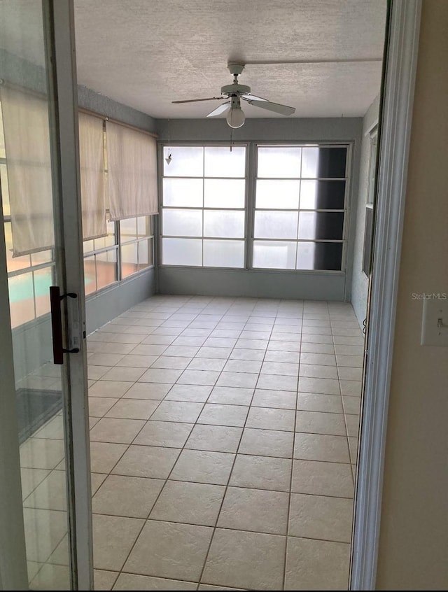 unfurnished sunroom featuring ceiling fan