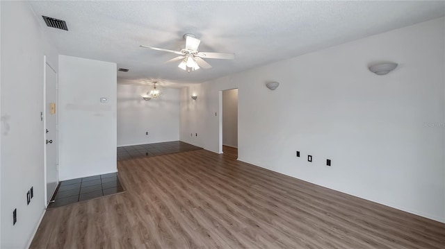 spare room featuring ceiling fan, a textured ceiling, wood finished floors, and visible vents