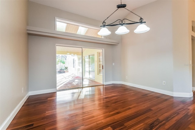 unfurnished dining area with dark wood-type flooring and a high ceiling