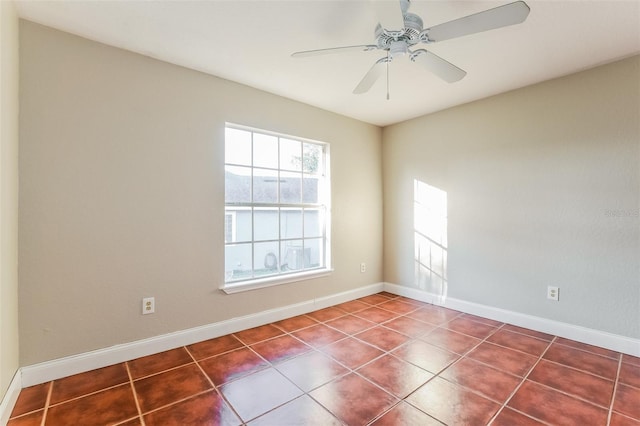 spare room with dark tile patterned flooring and ceiling fan