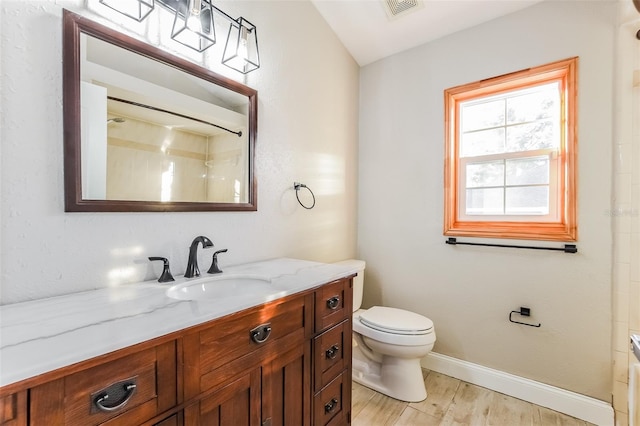 bathroom with a shower, hardwood / wood-style floors, vanity, and toilet