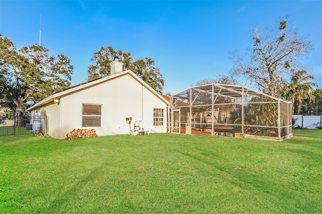 back of house featuring a lanai and a lawn