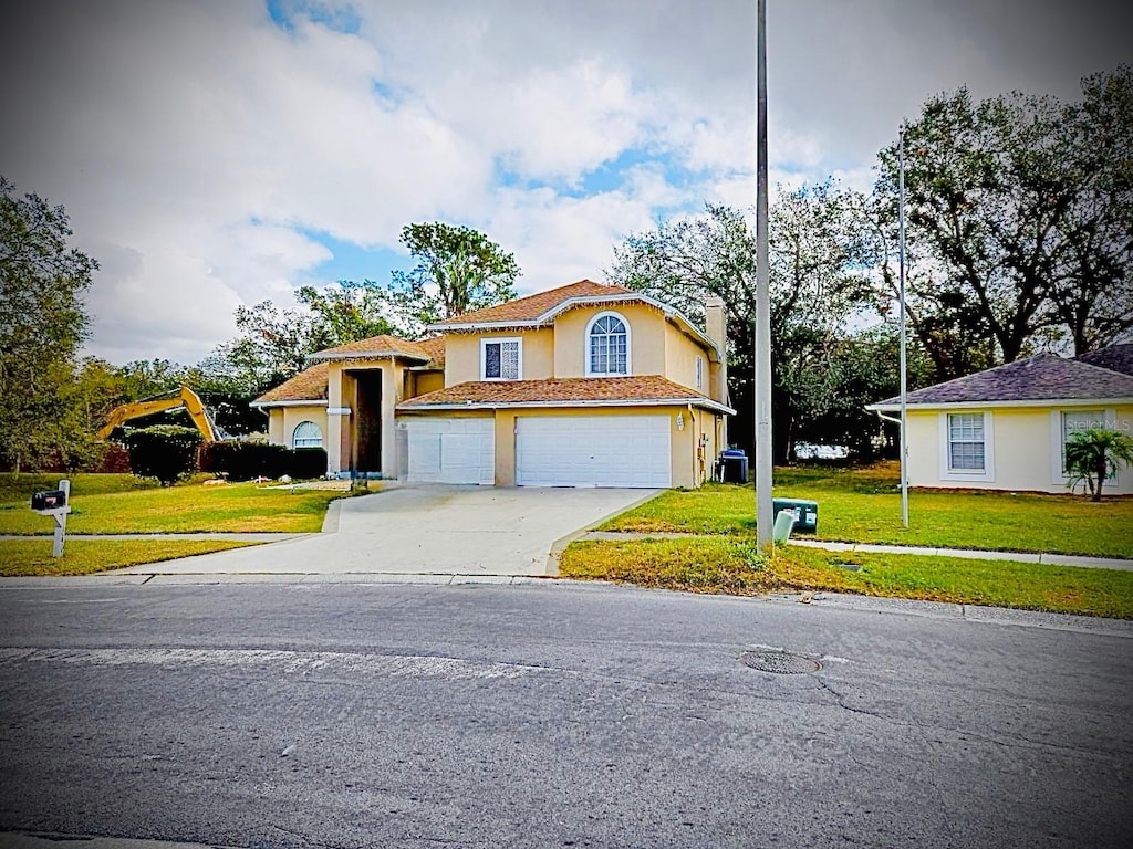 view of front of home with a front yard and a garage