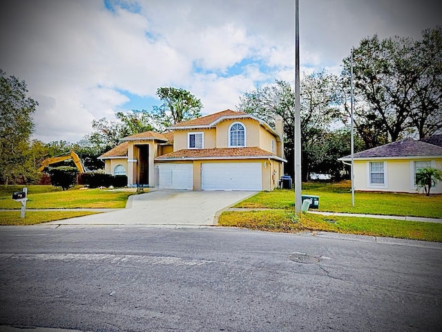 view of front of home with a front yard and a garage