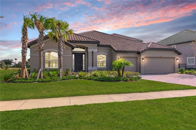 mediterranean / spanish-style house featuring a yard and a garage