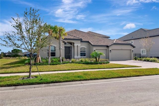 mediterranean / spanish-style house featuring a front yard and a garage