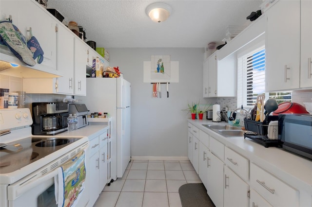 kitchen featuring tasteful backsplash, sink, white cabinets, and white appliances