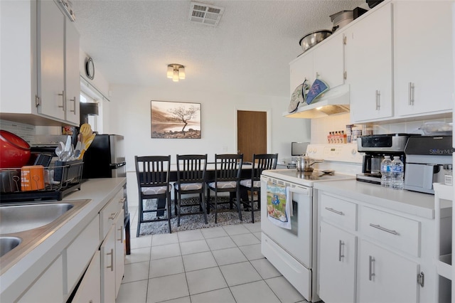 kitchen with exhaust hood, white range with electric cooktop, a textured ceiling, light tile patterned flooring, and white cabinetry