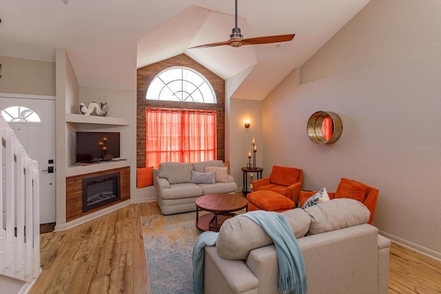 living room featuring vaulted ceiling, ceiling fan, and light wood-type flooring