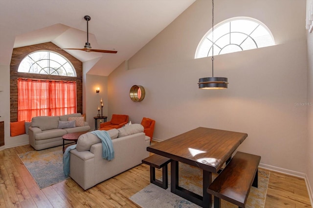 living room featuring high vaulted ceiling, light hardwood / wood-style floors, and ceiling fan