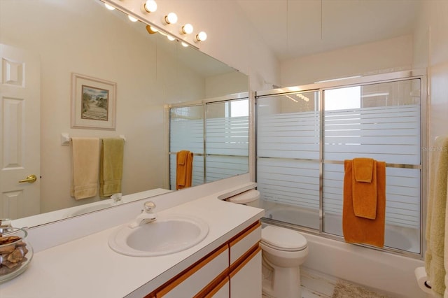 full bathroom featuring vanity, bath / shower combo with glass door, and toilet