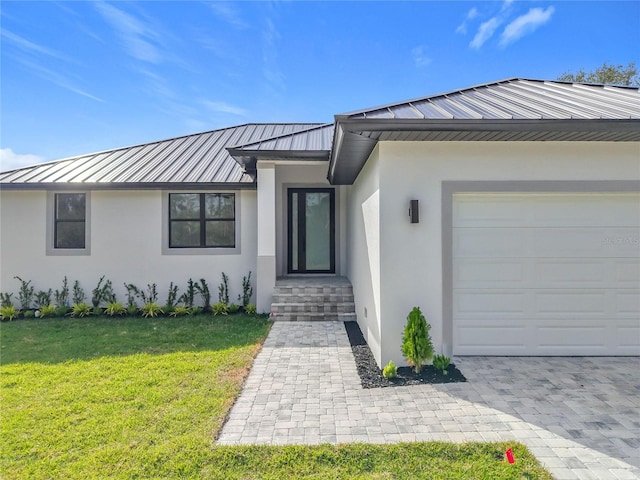 doorway to property with a lawn and a garage