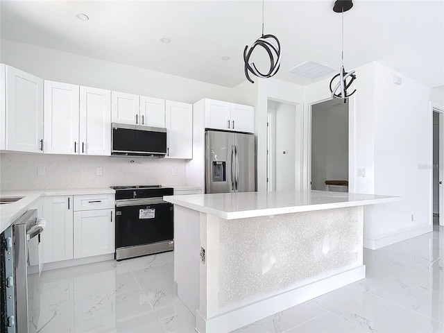 kitchen featuring a center island, hanging light fixtures, a notable chandelier, white cabinets, and appliances with stainless steel finishes