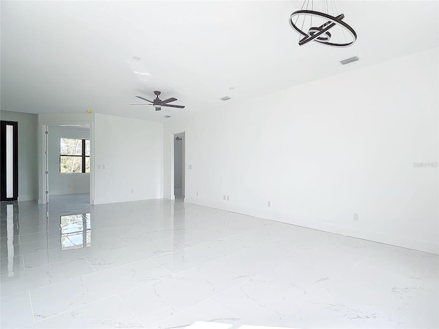 spare room with ceiling fan with notable chandelier