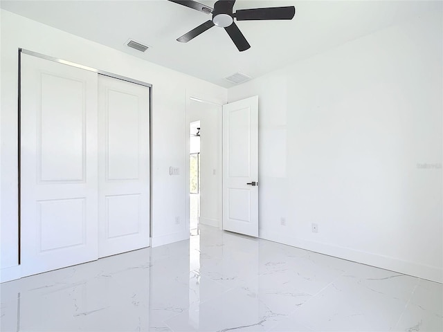 unfurnished bedroom with ceiling fan and a closet