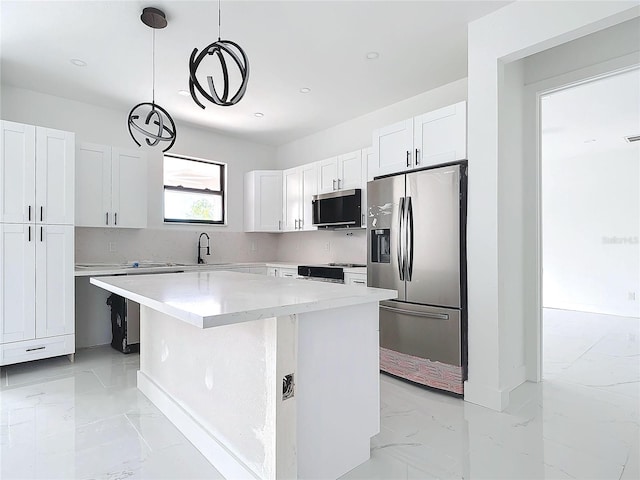 16760 Acapulco Rd, Punta Gorda, FL 33955 - kitchen featuring stainless steel appliances, light marble finish floors, white cabinetry, a kitchen island, and recessed lighting