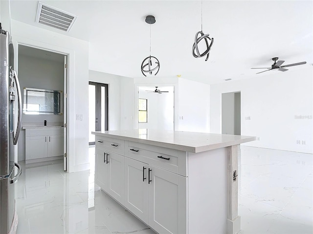16760 Acapulco Rd, Punta Gorda, FL 33955 - kitchen featuring ceiling fan, light marble finish floors, freestanding refrigerator, a kitchen island, and hanging light fixtures
