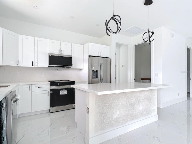 16760 Acapulco Rd, Punta Gorda, FL 33955 - kitchen featuring stainless steel appliances, light marble finish floors, a kitchen island, white cabinetry, and decorative light fixtures
