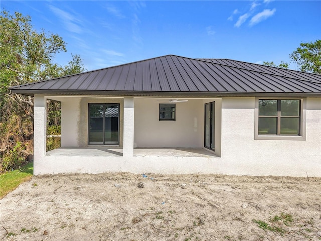 16760 Acapulco Rd, Punta Gorda, FL 33955 - back of property with stucco siding, a patio area, and a metal roof