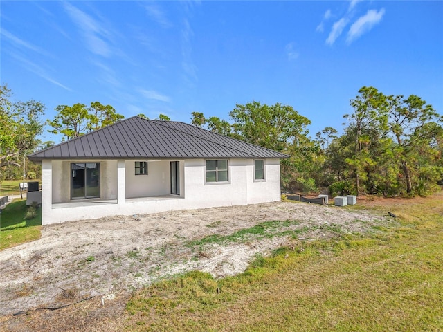 16760 Acapulco Rd, Punta Gorda, FL 33955 - rear view of property with stucco siding, a metal roof, a standing seam roof, and a lawn