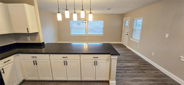 kitchen featuring a textured ceiling, white cabinets, dark wood-type flooring, and decorative light fixtures