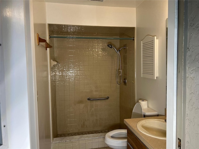 bathroom with a tile shower, vanity, and toilet