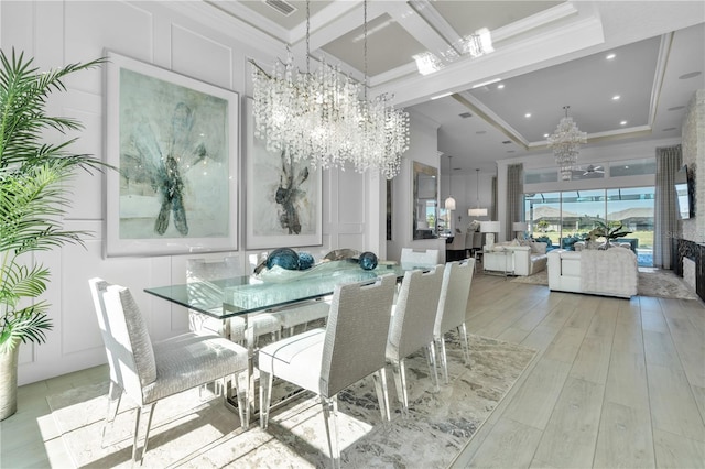 dining room featuring a chandelier, light wood-type flooring, and ornamental molding