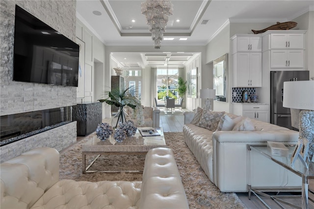 living room with a raised ceiling and crown molding